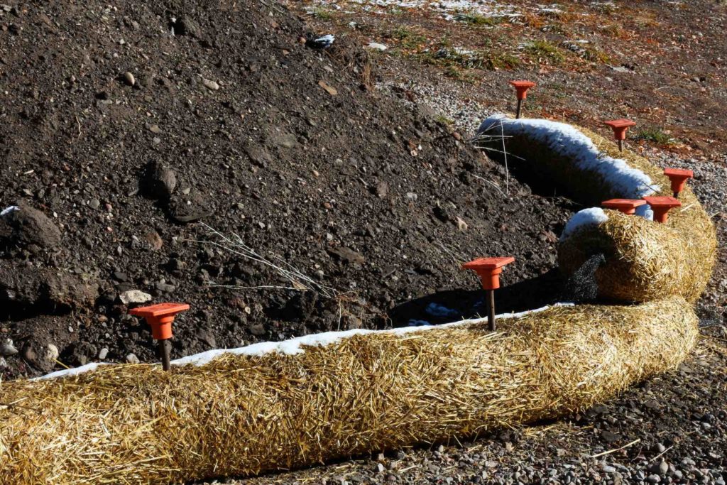 Arc of Fiber Rolls keeping black soil from eroding