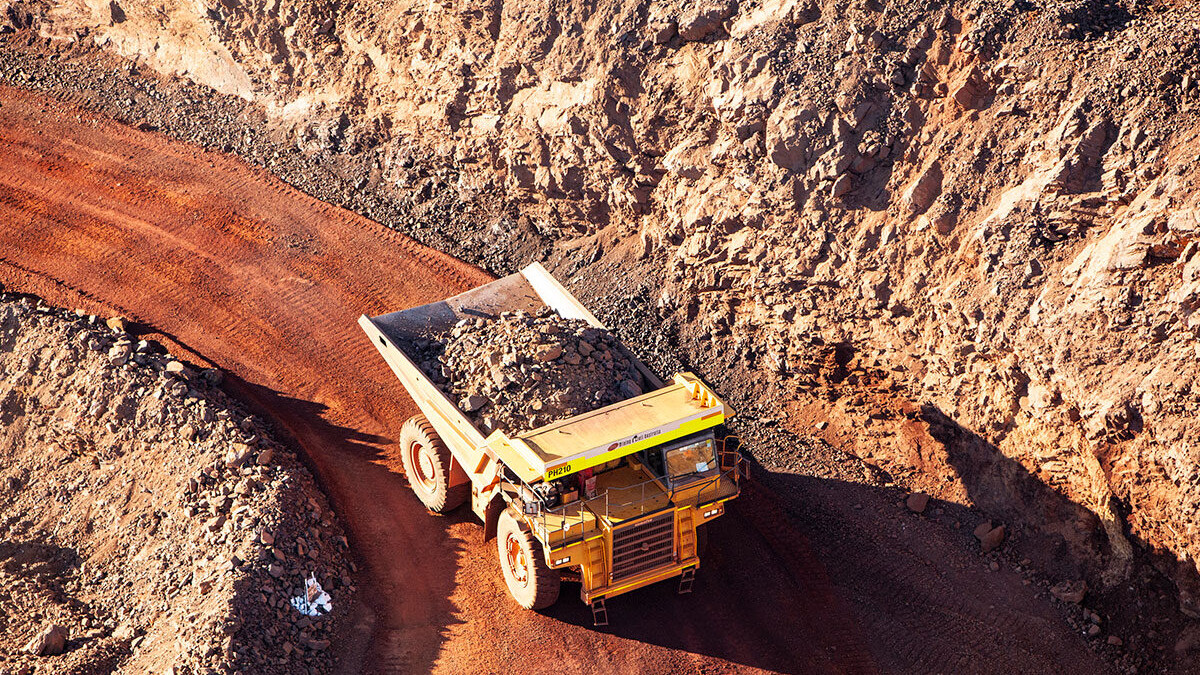 Mining truck carrying loads along a dusty haul road