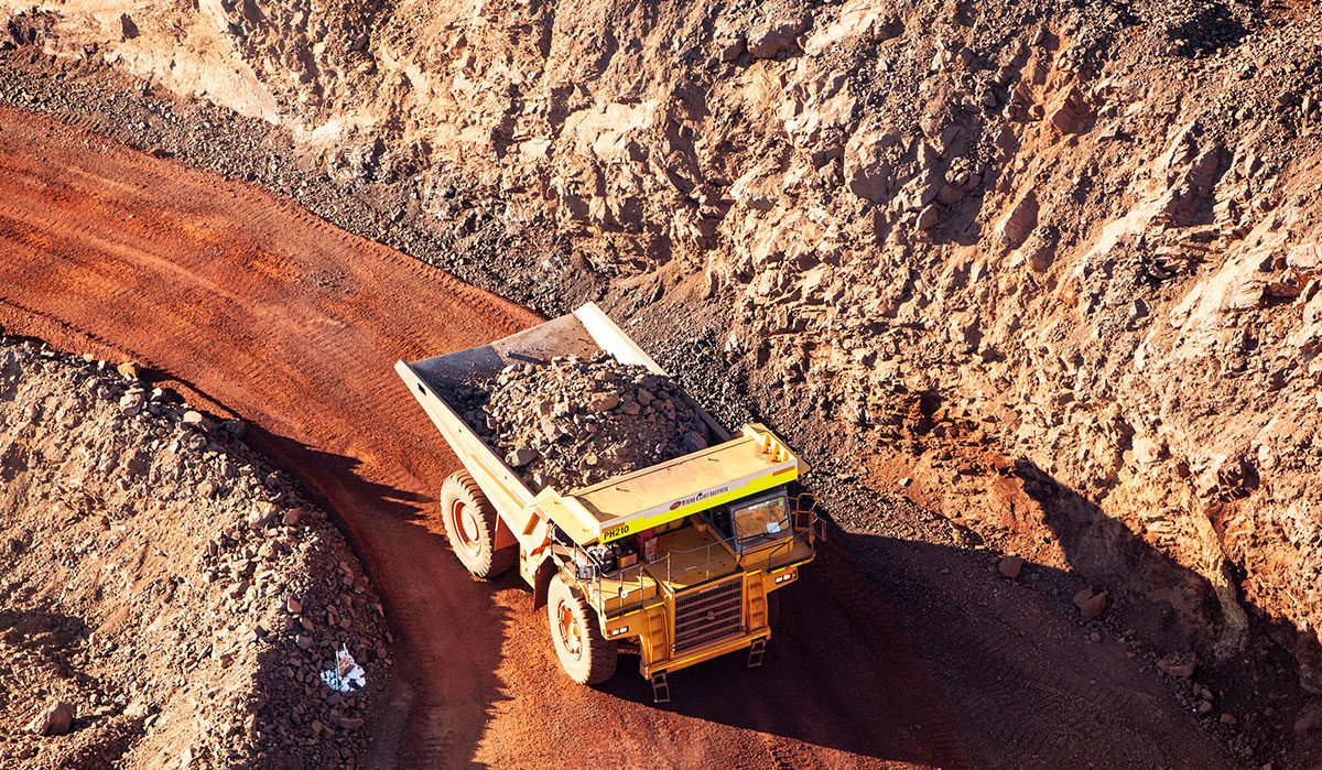 Mining truck carrying loads along a dusty haul road